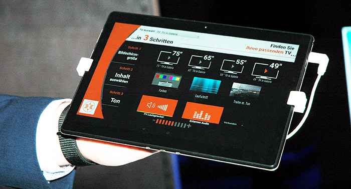 Auf einem Tablet können per Tastendruck auf einen TV-Display die verschiedenen Bildschimrgrößen simuliert werden